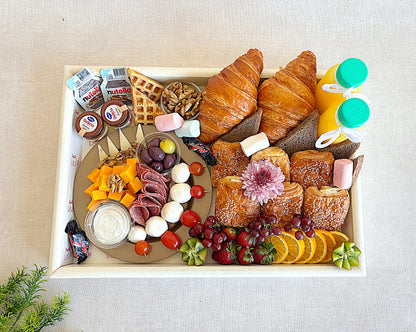 Assorted breakfast items including pastries, fruits, and spreads on a tray.