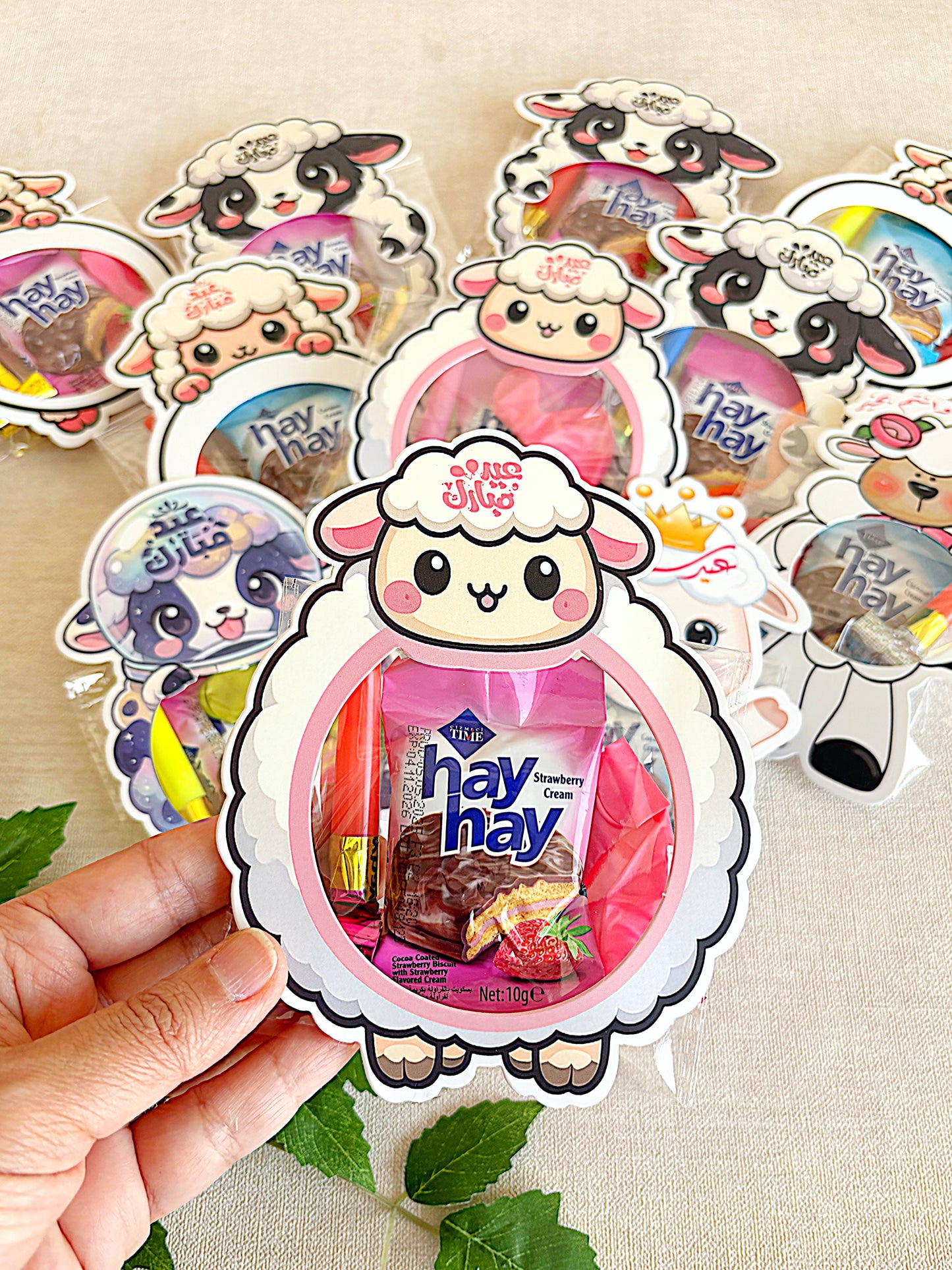 Sheep-shaped candy package with 'hay hay' branding held by a hand on a beige background.