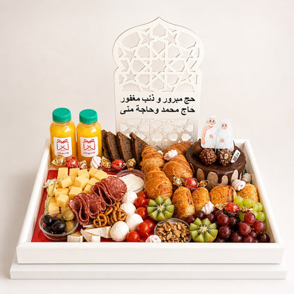 Assorted food platter with drinks, pastries, fruits, and other snacks on a white tray.