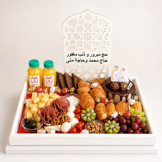 Assorted food platter with drinks, pastries, fruits, and other snacks on a white tray.